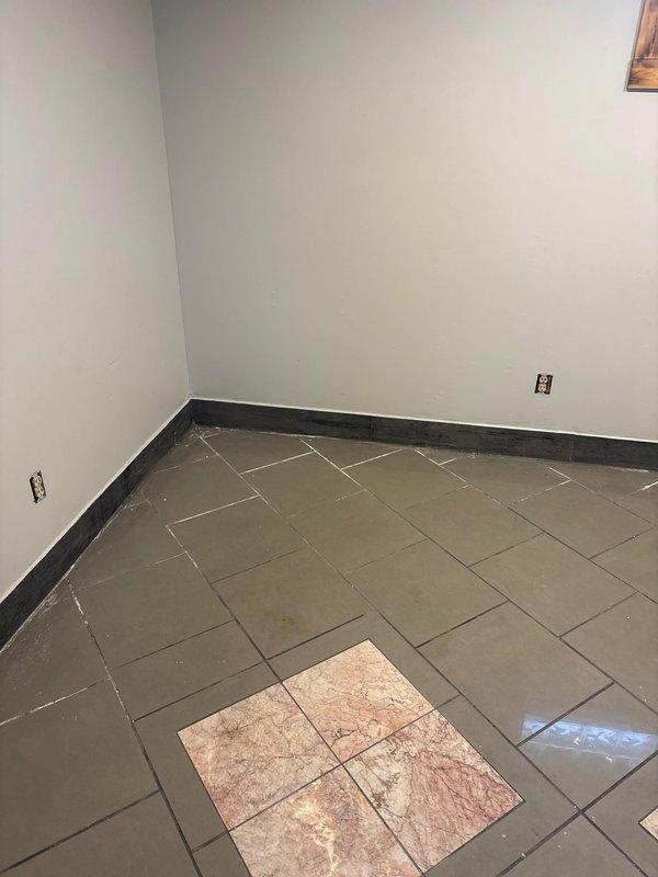 Performed complimentary electrical inspection of unfinished interior space. Examined exposed outlet boxes in main room with tiled flooring that appears to be under renovation. Also inspected electrical outlet and connected power cord in utility area where plumbing pipes are installed, noting wall deterioration including cracks and water stains that could potentially affect electrical safety.