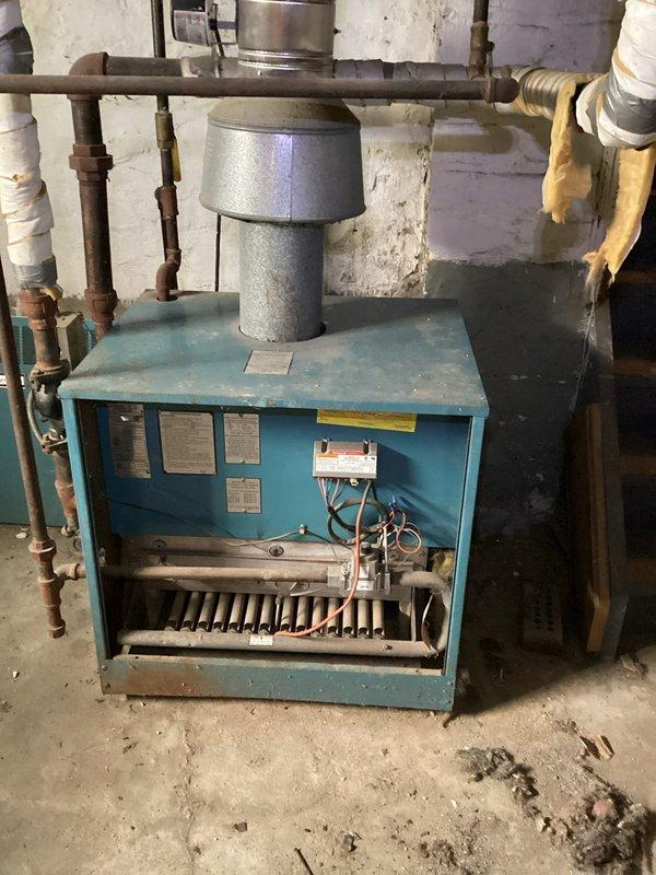 Performed routine tune-up on aging blue boiler system located in basement. Inspected Honeywell control unit, heat exchanger fins, and flue connections for proper operation. Cleaned components, verified proper combustion, and confirmed system safety controls were functioning correctly.