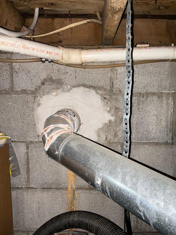 Completed assessment of 10-year-old Carrier furnace with cracked heat exchanger. Inspection revealed rusting exhaust flue pipe where it penetrates the concrete wall, with visible water staining indicating possible condensation issues. Customer has previous estimate and concerns about current unit being oversized for the residence.