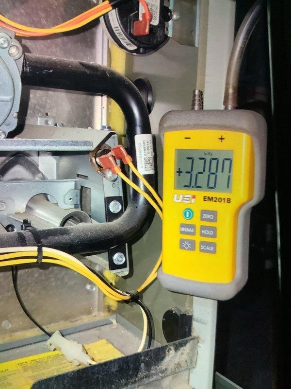 Performed maintenance on a gas furnace of undetermined age. Conducted electrical measurements using UEi EM2018 meter, obtaining readings of 3287 on system components. Inspected blower motor, heat exchanger, and wiring connections for proper operation. Evaluated ductwork condition to assess need for cleaning service.