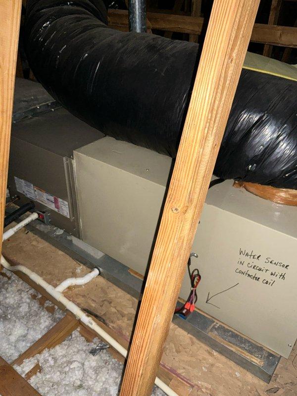 Completed installation of an 80% efficiency furnace in open attic space. Installed unit with proper clearances between wooden structural supports, ensuring adequate airflow through the black insulated ductwork. Added water sensor connected to contactor coil as safety measure, with condensate drainage system properly connected via PVC piping.