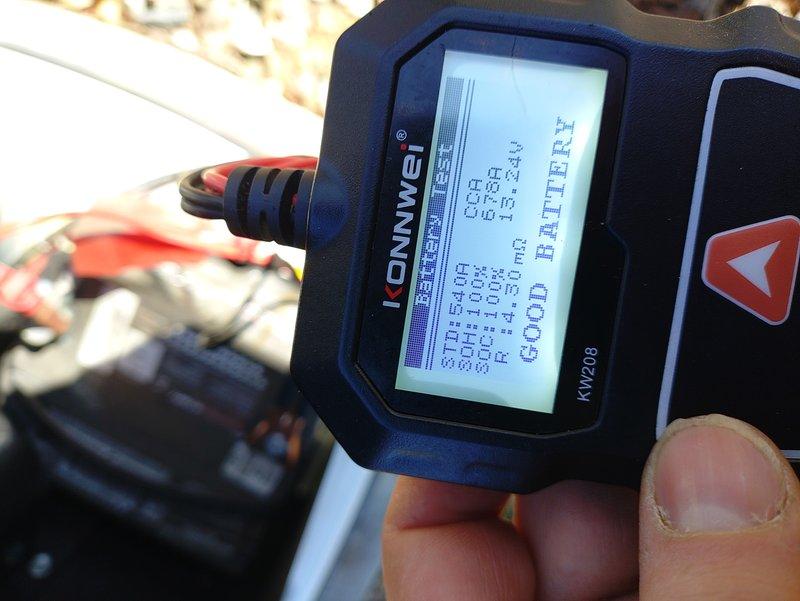 Performed diagnostic testing on residential backup generator system showing alert indicator (non-green status light). Battery test using Konwei KW208 analyzer confirmed battery is in good condition (CCA: 609, SOH: 87.8%, SOC: 100%, IR: 1.40mΩ). Reset system controls and verified proper operation with green status indicator now illuminated.