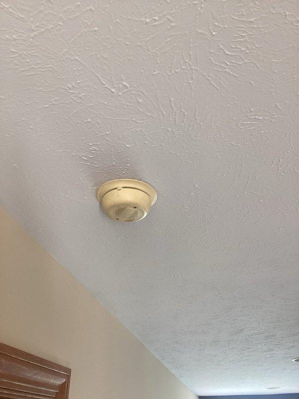 Responded to service call regarding recurring alarm activation from smoke detector. Upon inspection, found smoke detector malfunctioning. Dismantled unit from ceiling mount to examine wiring connections, revealing loose yellow and red wires that were causing intermittent false alarms. Secured wiring connections and reinstalled detector, then tested system to confirm proper operation with no further alarm activations.