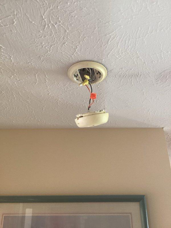 Responded to service call regarding recurring alarm activation from smoke detector. Upon inspection, found smoke detector malfunctioning. Dismantled unit from ceiling mount to examine wiring connections, revealing loose yellow and red wires that were causing intermittent false alarms. Secured wiring connections and reinstalled detector, then tested system to confirm proper operation with no further alarm activations.