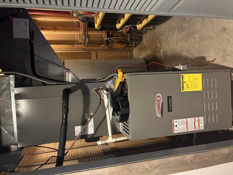Performed MVP Cooling maintenance service on residential Lennox HVAC system located in utility room. Inspected interior components including motor, circuit board, and refrigeration system, noting normal operational wear without obvious damage. Documented system condition with photos showing furnace unit with connected ductwork, condensate drainage, and electrical components, all appearing to be in working order.