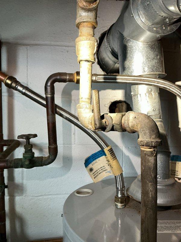 Responded to emergency service call regarding 9-year-old leaking and non-functional hot water tank. Diagnosed significant corrosion and failure on existing unit's connections and tank body. Completed full replacement with new Bradford White Defender Safety System water heater, including installation of new copper supply lines, brass fittings, and proper venting configuration to ensure code compliance and optimal performance.