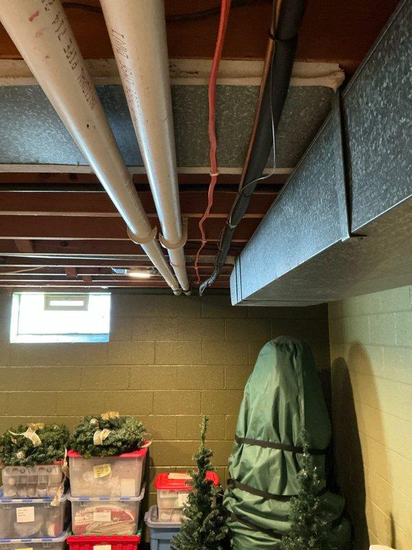 Conducted estimate for replacement of 18-year-old furnace and AC system with cracked heat exchanger. Inspected basement mechanical area where current HVAC system is installed, noting adequate utility infrastructure with accessible PVC venting and electrical connections. Evaluated existing Honeywell thermostat which would need replacement during system upgrade.
