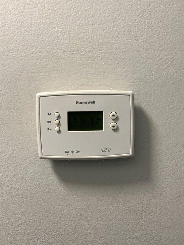 Conducted estimate for replacement of 18-year-old furnace and AC system with cracked heat exchanger. Inspected basement mechanical area where current HVAC system is installed, noting adequate utility infrastructure with accessible PVC venting and electrical connections. Evaluated existing Honeywell thermostat which would need replacement during system upgrade.