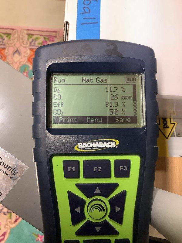 Performed annual furnace tune-up and diagnostic testing due to customer complaint of loud noise during fan operation. Conducted combustion analysis with Bacharach analyzer showing 81.0% efficiency, CO levels at 26ppm, and CO2 at 5.2% for natural gas system. Inspected internal components with access panel removed, adjusted fan assembly to eliminate noise issue, and verified proper system operation before completion.