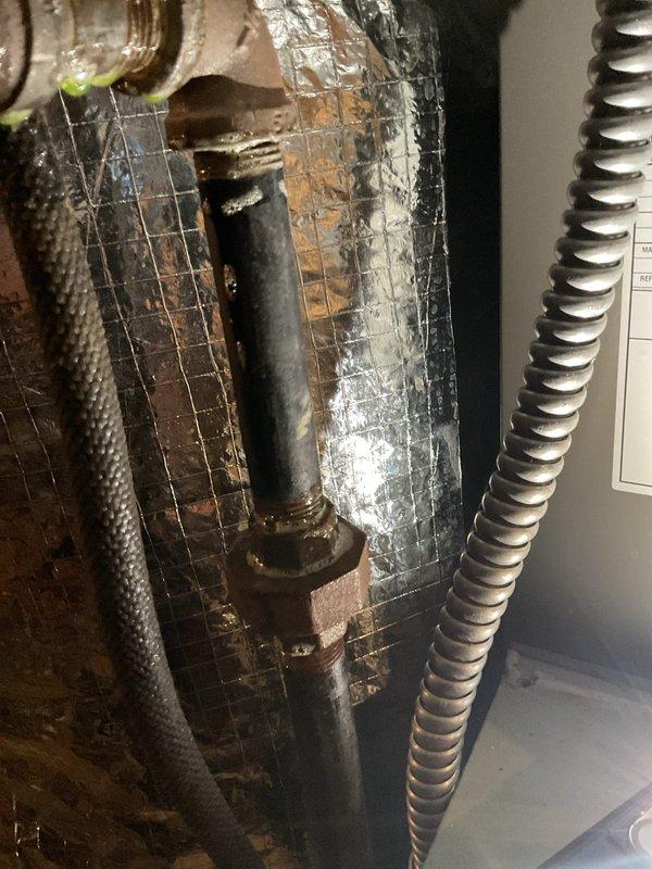 Performed minimum viable product heat visit which included inspection of pipe connections and fittings. Conducted electrical testing with multimeter showing 16.2V reading on system components. Documented visible corrosion on metal surfaces and verified condition of insulation materials and flexible conduits.