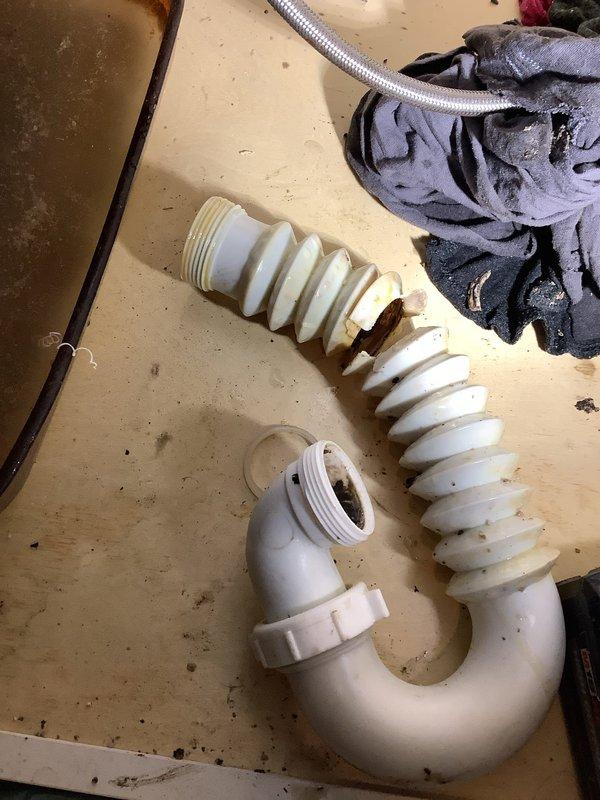 Replaced deteriorated kitchen drain piping in crawlspace, cutting cabinet access point to properly install new PVC trap assembly. Installed approximately 35' of new PVC piping to replace existing horizontal run, connecting to the existing ABS drain line to restore proper drainage function.