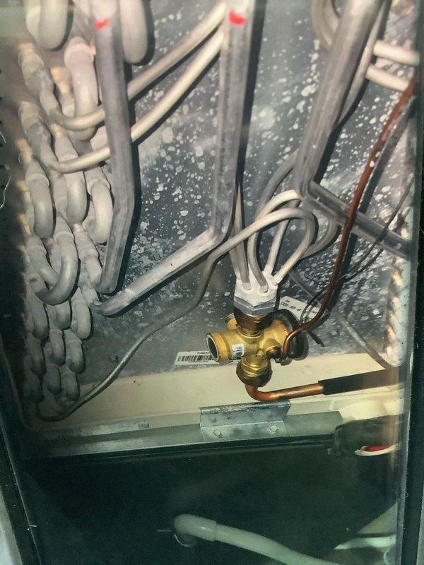 Conducted scheduled MVP Heating maintenance service and identified frost/ice buildup on evaporator coils indicating potential refrigerant flow issues. Inspected control valve assembly and connection points for proper operation, and noted condensation throughout system components that may require further monitoring.