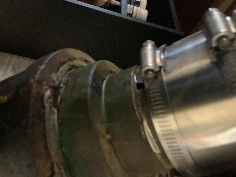 Repaired deteriorated 4" x 3" copper adapter connection at cast iron wye on high rough sewer line using service weight gasket. Modified existing 3" PVC drainage configuration by replacing a long sweep 90° fitting with two 45° elbows to improve flow characteristics and ensure proper drainage.