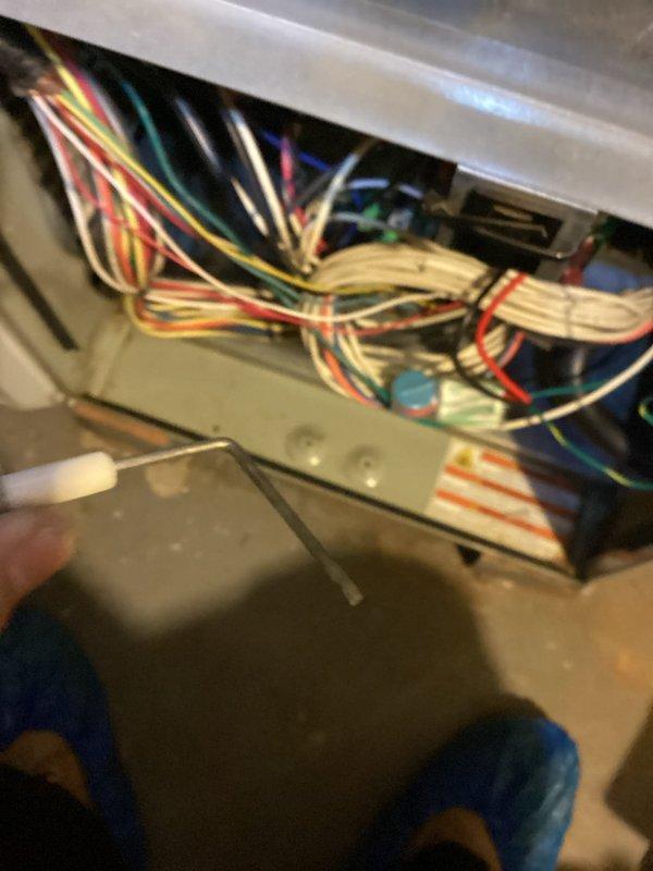 Performed routine maintenance on 13-year-old furnace as part of MVP recurring service. Inspected interior components showing significant rust and corrosion on metal tray. Examined and verified proper connection of control panel wiring harness containing multiple colored wires connected to terminal block.