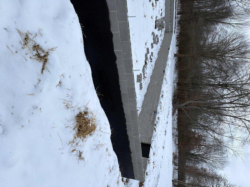 Performed site assessment for gas and water line installation to modular home. Documented winter site conditions, including snow-covered terrain, water feature and existing pathway that will impact installation planning. Photos taken to support comprehensive quote development.