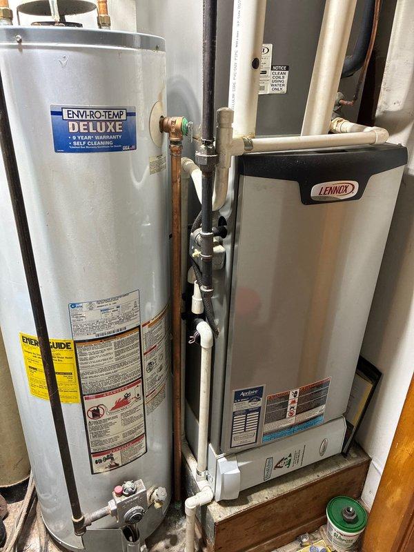 Performed scheduled MVP furnace maintenance on a Lennox heating system. Inspected and tested the main circuit board with terminal connections and DIP switches, confirming proper functionality. System includes integrated water heater setup with copper and PVC piping network; all components operating within normal parameters.