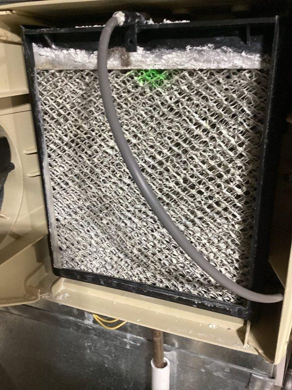 Performed routine maintenance on Lennox furnace system. Inspected air filter which showed signs of dust accumulation and requires replacement soon. System includes an Aprilaire humidifier with filter box mounted nearby. All components appear to be in good working condition with proper ventilation connections.