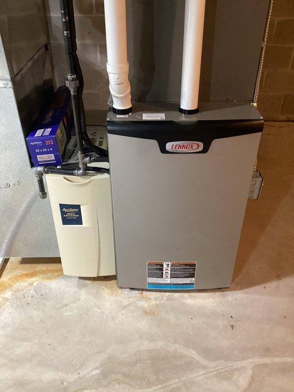 Performed routine maintenance on Lennox furnace system. Inspected air filter which showed signs of dust accumulation and requires replacement soon. System includes an Aprilaire humidifier with filter box mounted nearby. All components appear to be in good working condition with proper ventilation connections.