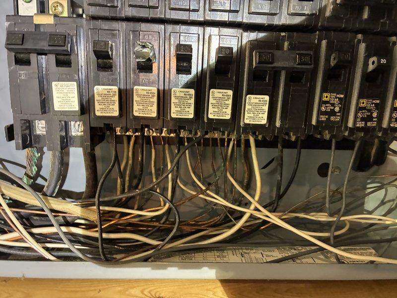 Inspected 1920s home electrical panel in response to repeated circuit breaker trips. Found outdated panel with inadequate capacity for modern electrical loads and observed signs of overheating at several breaker connections. Replaced two faulty breakers, reorganized wire management to reduce strain on connections, and recommended future upgrade to 200-amp service panel to prevent recurring issues.