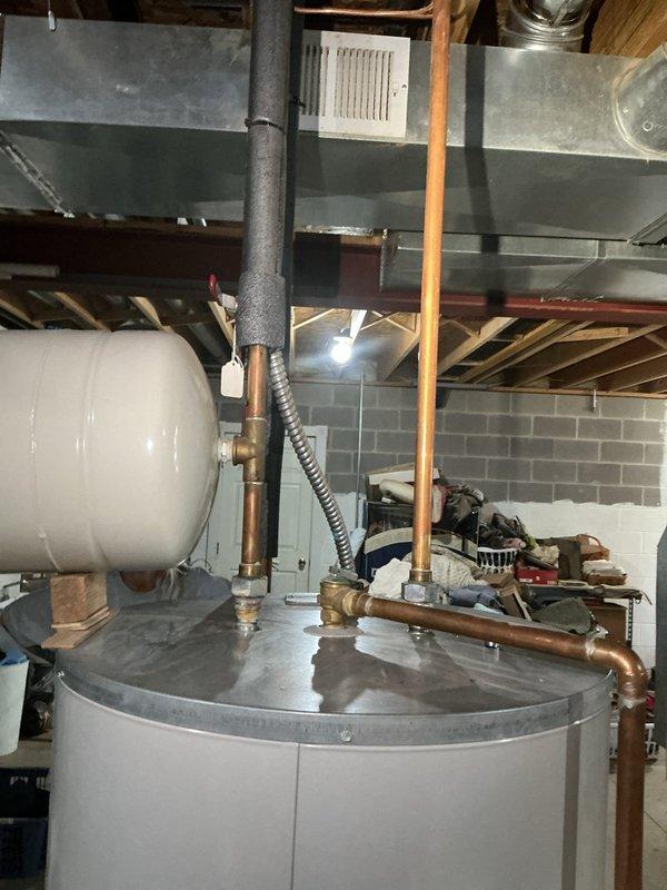 Successfully replaced leaking 80-gallon electric water heater with new Bradford White light duty commercial unit. Rebuilt geo thermal lines at tank bottom with 3/4" fittings adapted to existing 1/2" pipe, reused boiler drain, and installed new thermal expansion tank. Two-person team required for removal and installation in basement location.