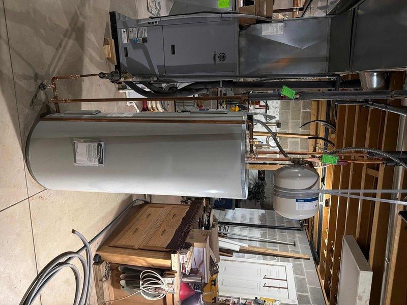 Successfully replaced leaking 80-gallon electric water heater with new Bradford White light duty commercial unit. Rebuilt geo thermal lines at tank bottom with 3/4" fittings adapted to existing 1/2" pipe, reused boiler drain, and installed new thermal expansion tank. Two-person team required for removal and installation in basement location.