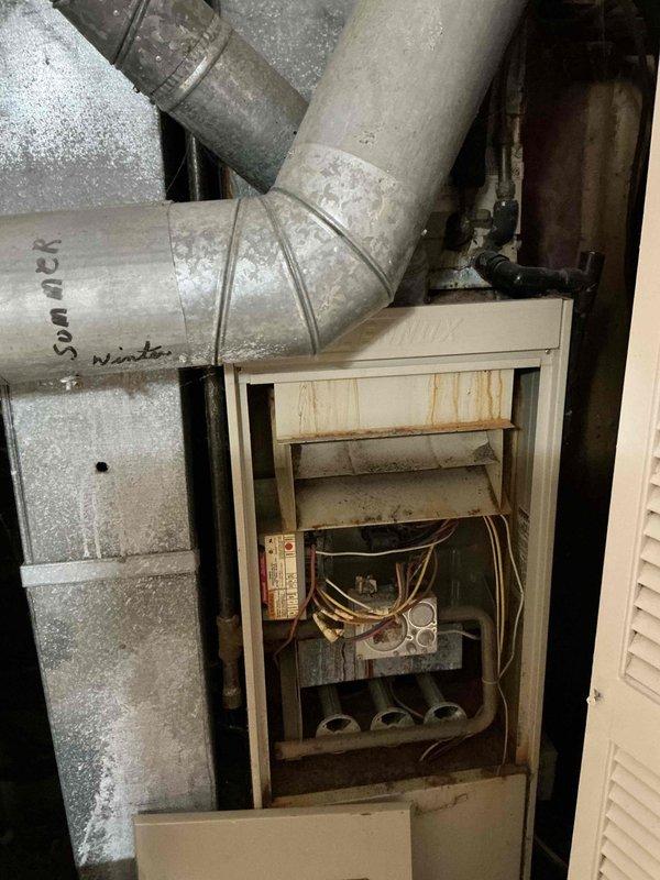 Performed comprehensive evaluation of 40-year-old HVAC system showing significant wear, including visible rust stains and water damage on cabinet exterior. Inspection revealed aged internal components with dust accumulation throughout, particularly on control board connections and ductwork junctions, indicating end-of-life condition and recommending full system replacement.