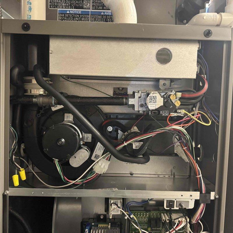 Performed scheduled maintenance on furnace system. Inspected interior components including blower motor, electrical connections, and circuit board with DIP switches. Verified proper operation of leak detection system and confirmed all components were intact and functioning correctly.