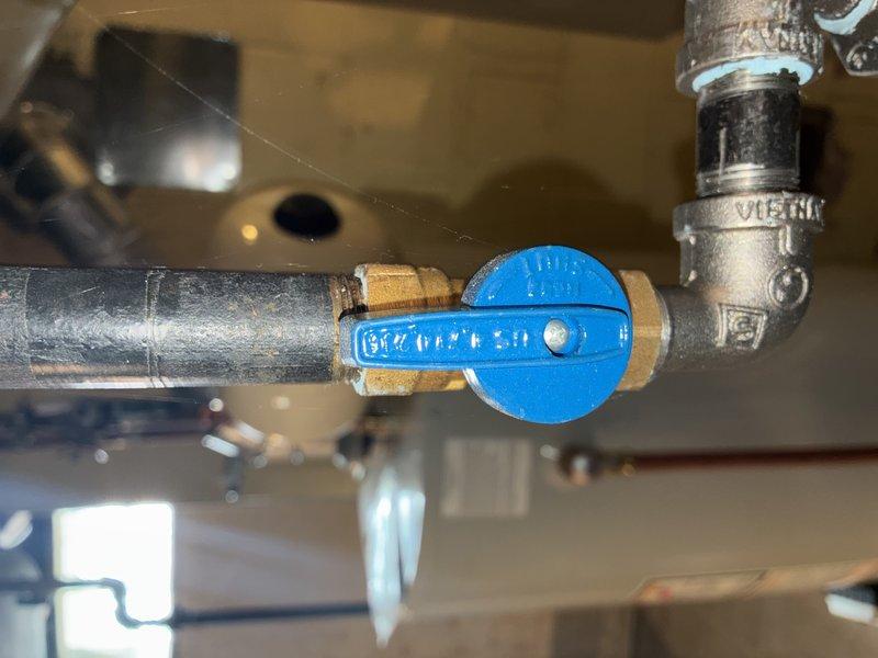 Conducted routine maintenance on the HVAC heating system, inspecting the mechanical utility area including ductwork, ventilation components, and associated plumbing network. Examined the blue valve handle and brass fittings for proper operation, confirming all connections were secure with no signs of corrosion or leakage in the piping system.