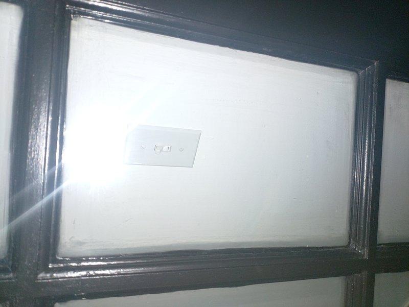 Conducted site assessment for overhead lighting installation in two rooms of a 1990s residential property. Evaluated existing wall structures featuring vertical paneling and identified suitable mounting locations for new fixtures. Documented current electrical switch configurations to determine appropriate wiring requirements for the requested lighting upgrade.