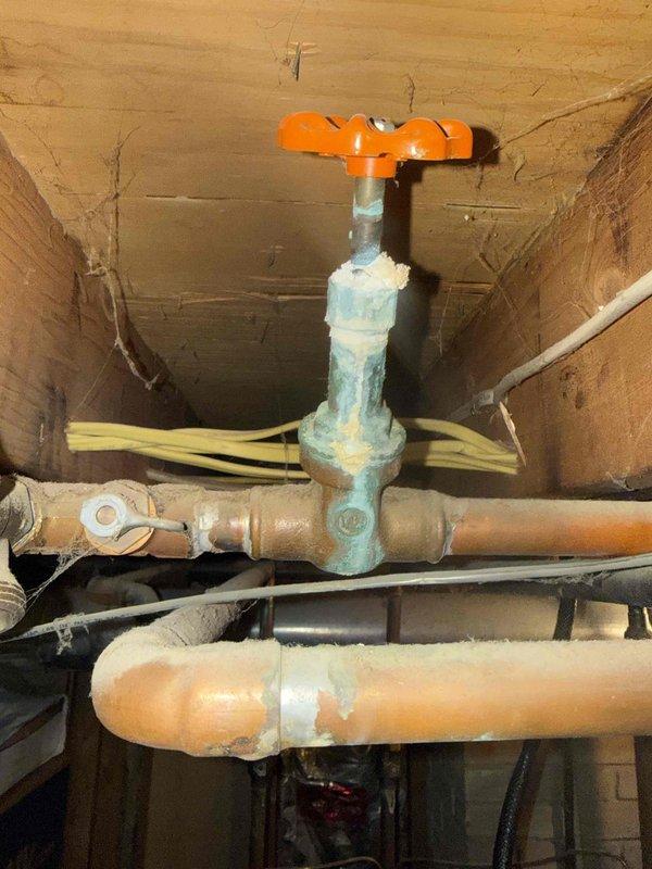 Performed scheduled MVP maintenance service on 21-year-old boiler system. Inspected electrical transfer switch connections and noted significant corrosion on copper water valve with orange handle. Documented aging plumbing infrastructure with oxidation present at connection points for future reference.