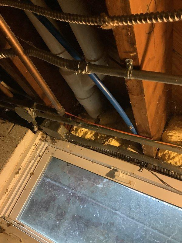 Conducted inspection of 13-year-old furnace and confirmed multiple cracks in heat exchanger with an efficiency rating of 3/5. Documented evidence of deterioration via photographs showing the furnace installation area and the Trane unit with connected PVC ventilation pipes. Recommended replacement due to safety concerns and age of equipment.