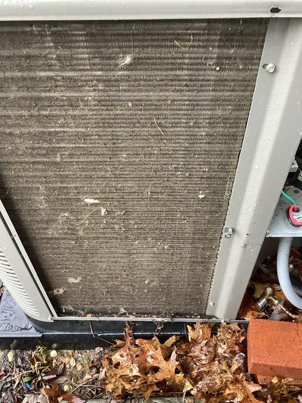 Performed routine cooling maintenance and identified severely clogged condenser coils with heavy dust, debris, and organic matter accumulation at base of unit. Cleaned condenser coils to restore proper airflow and system efficiency, which should improve cooling performance and prevent potential system strain.