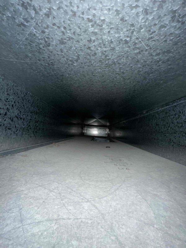 Completed comprehensive duct cleaning service on residential HVAC system, thoroughly removing accumulated debris and contaminants from supply and return ductwork. Inspection photos confirm successful cleaning of the galvanized sheet metal ducts, including proper treatment of the textured insulated surfaces and clearing of all vents including ceiling register with fan assembly. System now operating at optimal efficiency with improved indoor air quality.