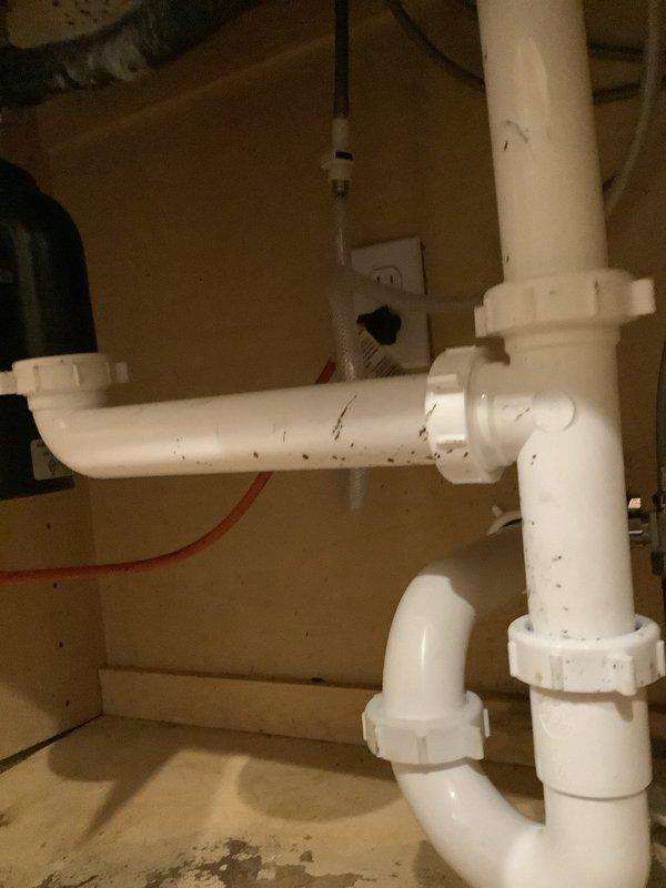 Completed installation of customer-supplied kitchen faucet with replacement of straight stops, snaked kitchen sink drain to clear backup, and replaced drain assembly with new basket strainer. Installed new PVC P-trap configuration under sink with proper connections to eliminate previous water staining/leakage issues observed during service.