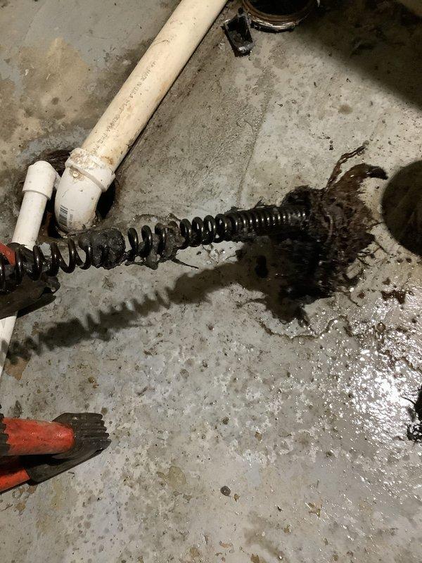 Responded to service call for main drain backing up during washer discharge. Upon inspection, discovered blockage in basement drain line. Successfully cleared obstruction using drain snake/auger, removing accumulated debris and restoring proper drainage. Verified system functionality with test run.