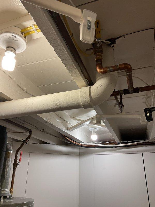 Cleared a clogged vent stack in the main drain system. Serviced the plumbing infrastructure in the basement utility area, focusing on the PVC and copper pipe network visible along the ceiling and walls. Restored proper drainage function to the system.