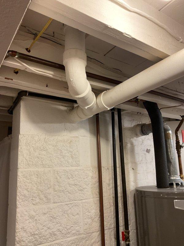 Cleared a clogged vent stack in the main drain system. Serviced the plumbing infrastructure in the basement utility area, focusing on the PVC and copper pipe network visible along the ceiling and walls. Restored proper drainage function to the system.