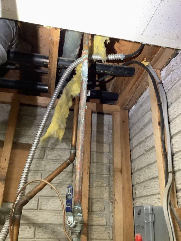 Performed diagnostic service on conventional tank-type water heater that repeatedly tripped circuit breaker. Reset breaker initially which restored operation temporarily, but unit failed again within 24 hours, indicating potential electrical component failure. Inspected installation components and documented existing plumbing configuration with photos for further analysis.