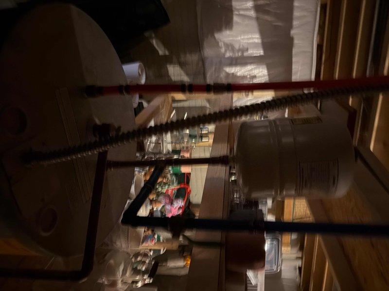 Performed comprehensive maintenance service on a 10-year-old tanked water heater, including inspection of copper pipe connections and flexible metal supply lines. Identified and addressed compressed insulation material around the tank base, and cleared debris from the utility area to ensure proper operation and extend equipment lifespan.