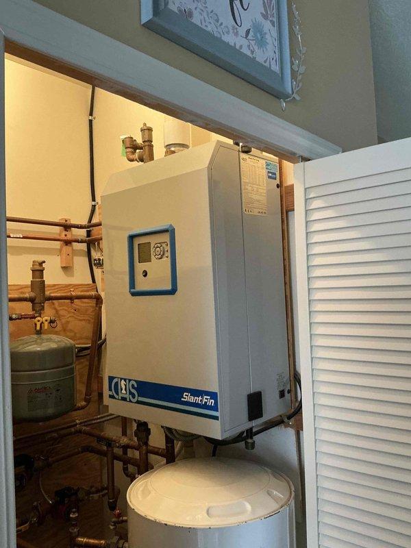 Performed comprehensive assessment of 2013 Navien NCB240-110H boiler system requiring replacement. Inspection revealed complex hydronic heating setup with multiple copper pipe zones, circulator pumps, expansion tanks, and associated valves. Current installation includes a CHS Slant Fin unit with integrated control system. Documented complete system configuration with photos to develop accurate replacement specifications.