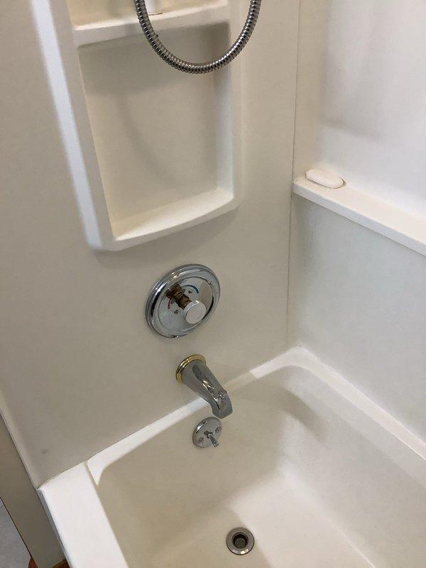 Conducted assessment for potential toilet replacement and shower valve installation. Inspection revealed standard white toilet on framed floor with no visible damage or issues. Existing shower/tub combination includes chrome faucet with gold accent ring and circular water control valve requiring replacement. No work was performed at this time as this was a quote-only visit.