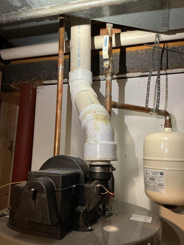 Conducted an on-site assessment for tankless water heater installation in a 36-year-old residence. Evaluated existing plumbing infrastructure, including copper supply lines, PVC drainage pipes, and current water heater system. Noted significant aging of components with visible mineral deposits and deterioration around pipe penetrations, which will require remediation during installation. Documented expansion tank condition and available utility connections for proper sizing and placement of new tankless unit.