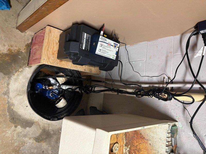 Responded to service call for sump pump alarm and non-functioning drainage. Upon inspection, found the submersible blue pump had failed due to sediment buildup at the bottom of the sump pit, causing the battery backup system to activate. Cleaned debris from pit, replaced faulty pump, tested system functionality, and verified proper operation of both primary pump and battery backup unit.