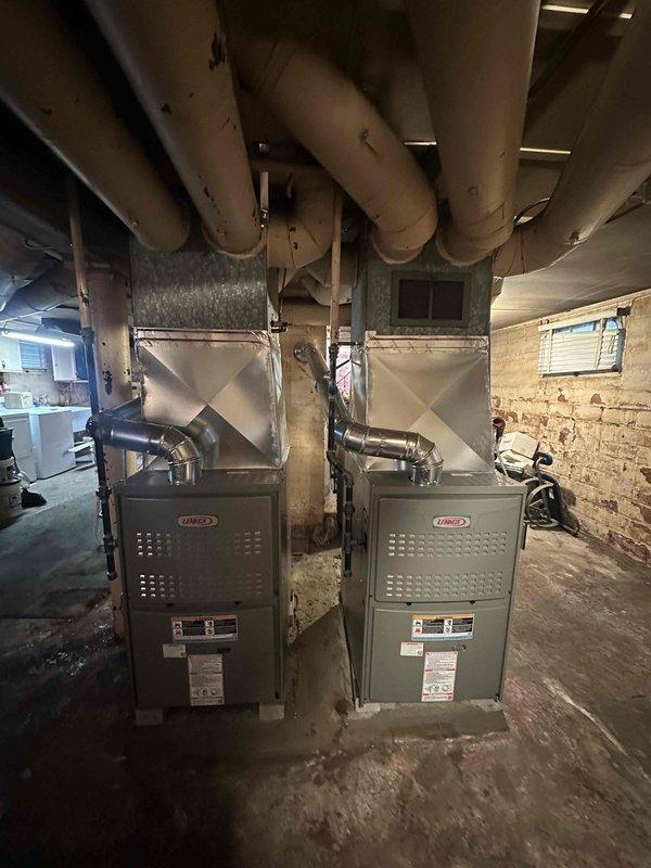 Successfully completed installation of dual Lennox 80% efficiency furnaces in basement utility area with proper ductwork connections. Established routing for clean air return system and connected all necessary components per specifications. Both units were properly installed with appropriate metal exhaust pipes and integrated into the existing circular duct distribution system.