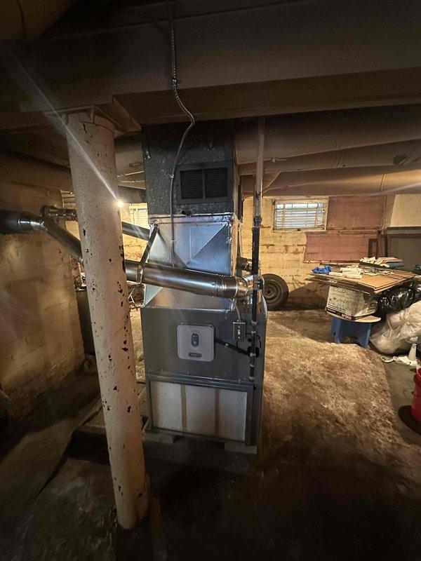 Successfully completed installation of dual Lennox 80% efficiency furnaces in basement utility area with proper ductwork connections. Established routing for clean air return system and connected all necessary components per specifications. Both units were properly installed with appropriate metal exhaust pipes and integrated into the existing circular duct distribution system.