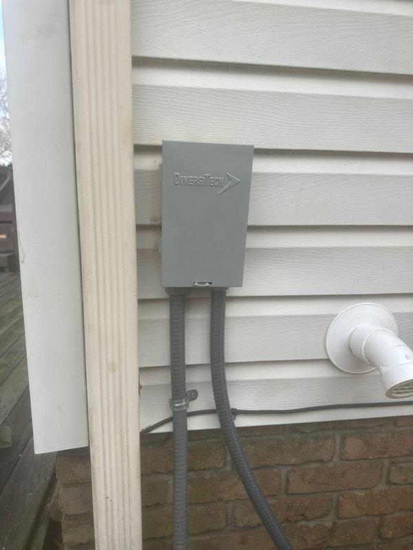 Completed installation of a 90K BTU air conditioning system with all required components. Installed a Kidde carbon monoxide alarm as part of the safety measures. Mounted DiversiTech junction box with proper conduit connections on exterior wall and installed PVC drain line for condensate removal.