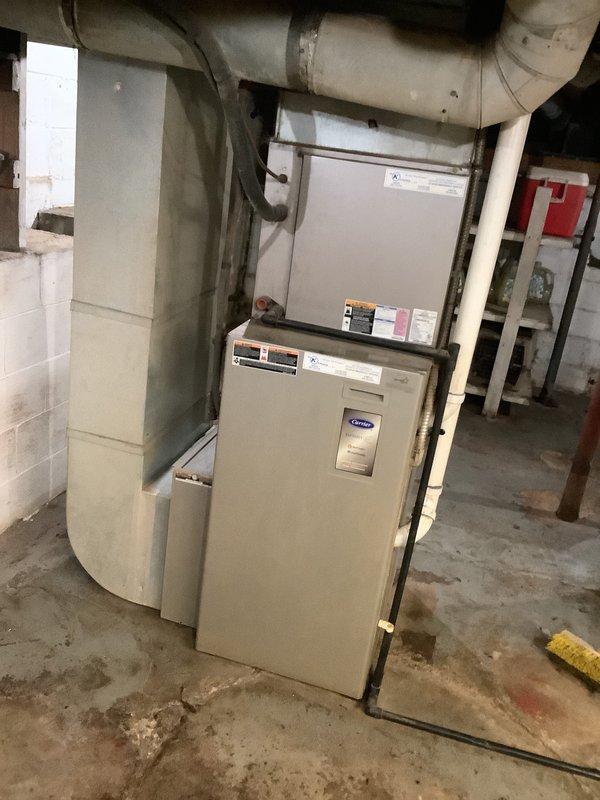 Conducted comprehensive assessment of 15-year-old HVAC system, including Carrier furnace unit and associated ductwork in basement utility area. Noted significant wall cracking near ventilation components and aging equipment condition. Provided replacement estimate for complete furnace and AC system upgrade with documentation of current installation configuration.