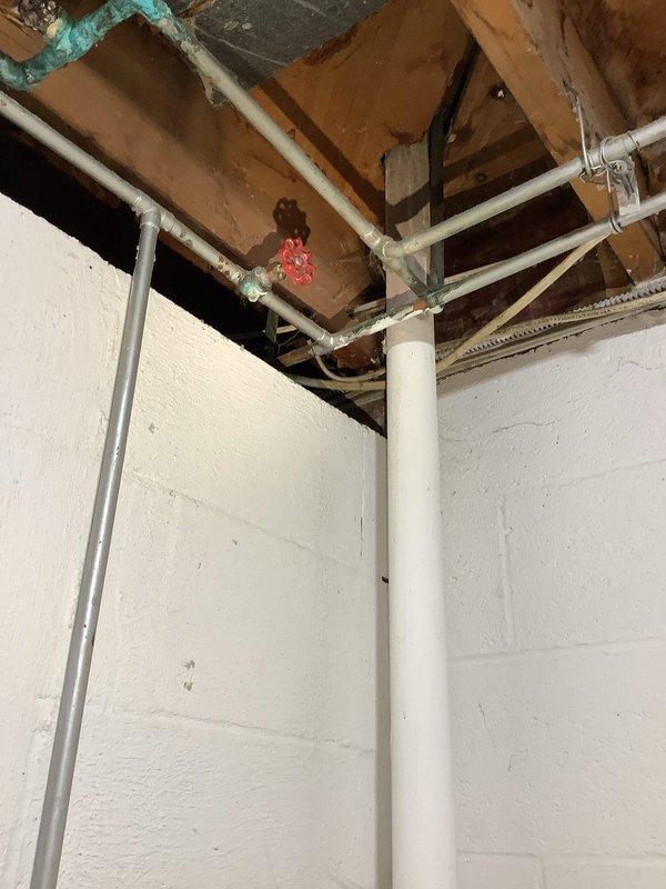 Responded to emergency water leak in basement of 65-year-old home. Located and operated main water shut-off valve which had significant corrosion and oxidation on copper pipes and valves. Addressed water accumulation and educated homeowner on location of main water valve for future reference.