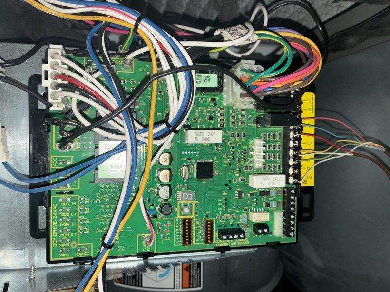 Performed routine maintenance on furnace of undetermined age. Inspected and replaced air filters with new diamond-patterned mesh filters. Examined control board circuitry and wiring connections (white, blue, yellow, green, red, black, and pink terminals) for proper functionality, all components found in normal working condition with no visible abnormalities.