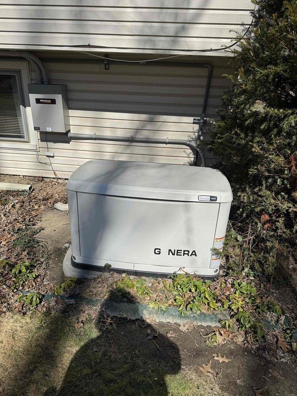 Performed routine maintenance on a 4-year-old Generac residential generator with blinking maintenance light. Inspected control panel (Evolution 2.0 interface) and verified system displays "READY TO RUN" status. Checked electrical connections at the transfer switch and confirmed proper installation on concrete pad with appropriate clearance from house siding.